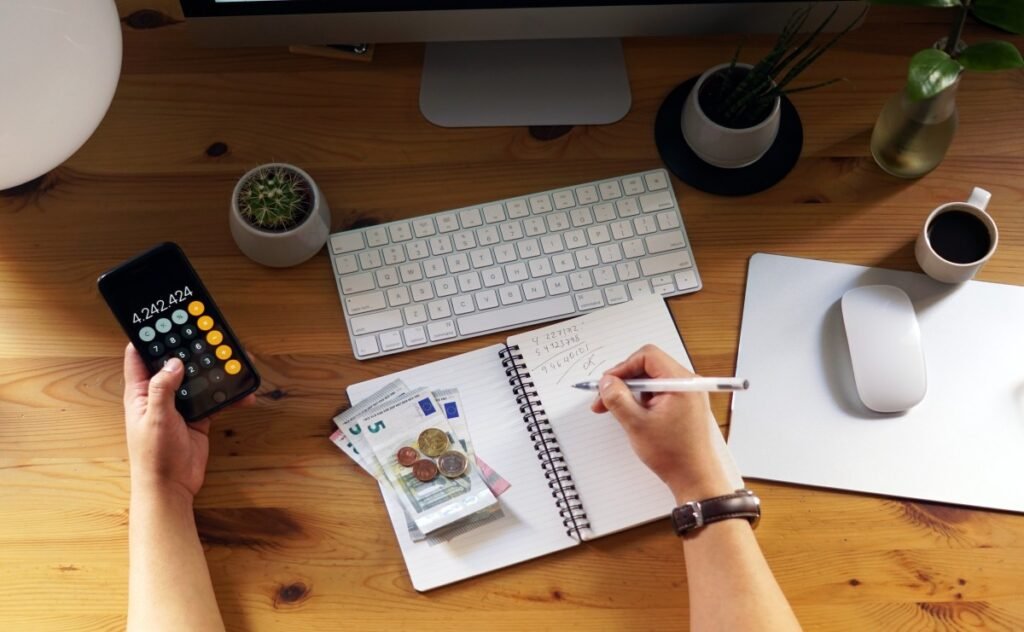 Person calculating expenses and budgeting at a desk.